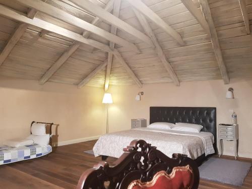 a bedroom with a large bed and wooden ceilings at Villa Renaissance in Flaujagues