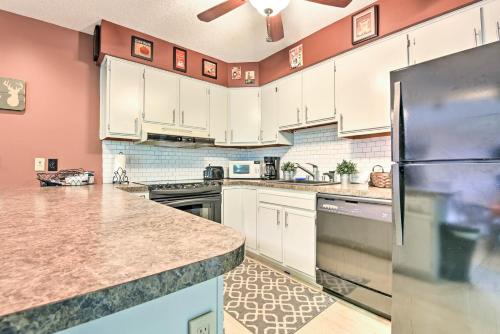 a kitchen with white cabinets and a black refrigerator at Peaceful Hamlin Home with Lake Access at The Hideout in Hamlin