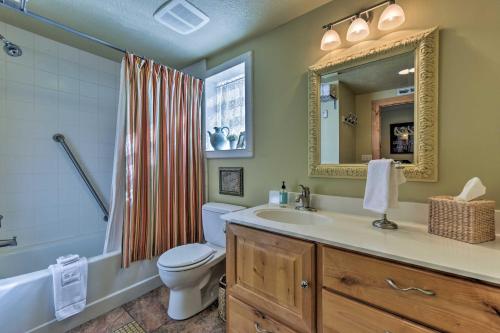 La salle de bains est pourvue de toilettes, d'un lavabo et d'un miroir. dans l'établissement Walkable Downtown Logan Apartment with Rooftop Deck, à Logan