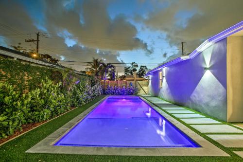 a swimming pool in a backyard with purple lighting at Modern Home with Shared Pool in Fort Lauderdale! in Fort Lauderdale
