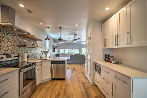 a large kitchen with white cabinets and wooden floors at Modern Home with Shared Pool in Fort Lauderdale! in Fort Lauderdale