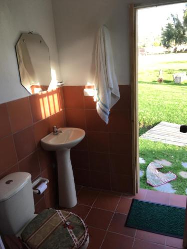 a bathroom with a sink and a toilet and a mirror at Posada Turistica Altamisal in Firavitoba