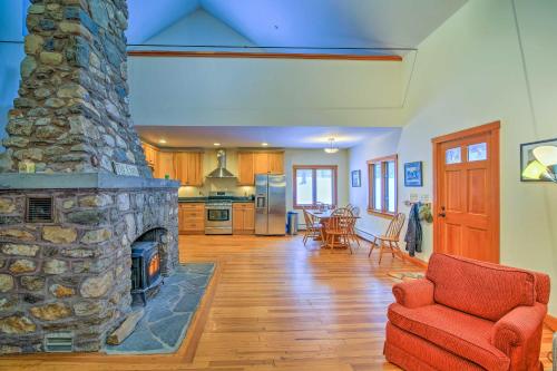 a large living room with a stone fireplace at Shelburne Studio Cabin with Spring-Fed Pool! in Shelburne