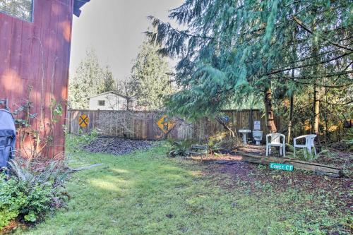 a yard with two chairs and a fence at Modern South Whidbey House - Steps to Tidal Flats! in Clinton