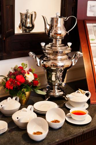 a silver tea pot sitting on top of a counter with dishes at THE GATE GARDEN Hotel in Berlin