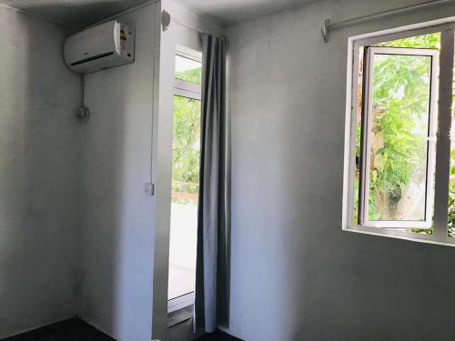an empty room with a window and an air conditioner at BREEZE DU NORD in Grand Baie