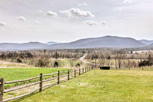 a fence in a field with mountains in the background at Quaint Elkton Home near Shenandoah National Park! in Elkton
