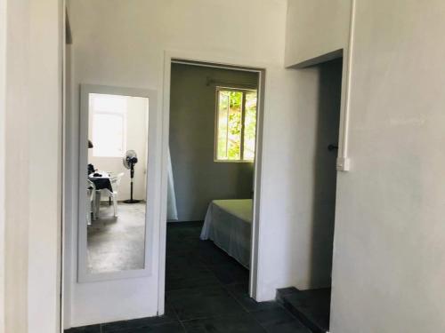 a hallway with a mirror and a bed in a room at BREEZE DU NORD in Grand Baie