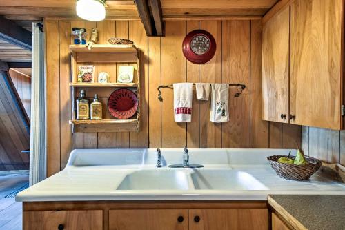 uma cozinha com um lavatório branco e paredes de madeira em Serene Washington Escape with Deck and Mountain Views! em Packwood