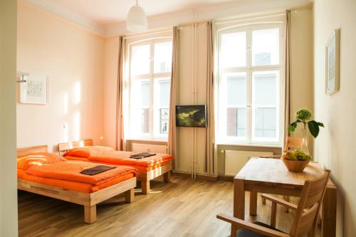 1 Schlafzimmer mit 2 Betten und einem Tisch in der Unterkunft Apartmentpension am Stadtschloss in Potsdam