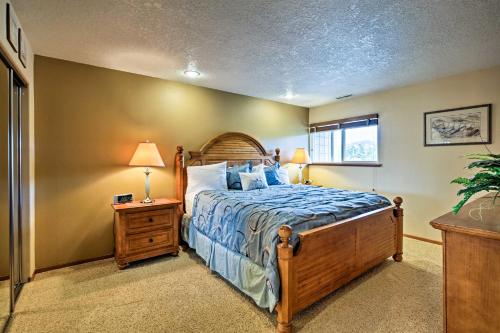 a bedroom with a bed with a blue comforter at Lincoln Beach Condo with Balcony and Ocean Views! in Lincoln City