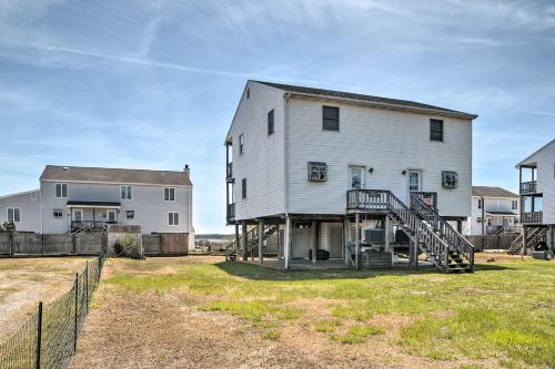 a large white house with a staircase in a yard at Chincoteague Townhome with Pony Views from Deck! in Chincoteague