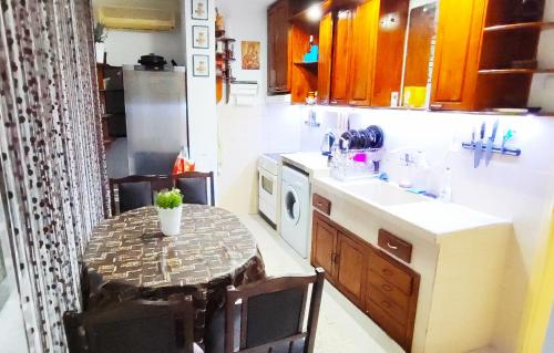 een kleine keuken met een tafel en een magnetron bij Уютен апартамент в Търговище - 2 спални и кухня in Targovishte