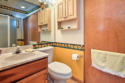a bathroom with a toilet and a sink and a mirror at Fort Atkinson Cottage on Lake Koshkonong with Deck! in Fort Atkinson
