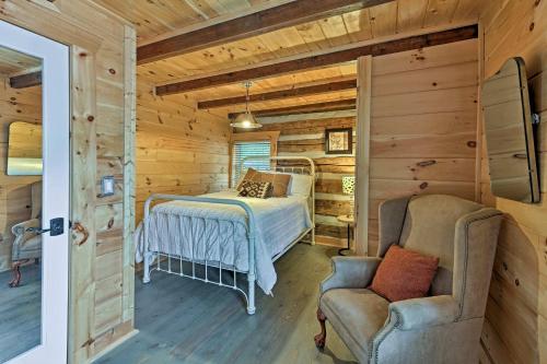 a bedroom in a log cabin with a bed and a chair at Douglas Lake Cabin with Dock - 25 Mi to Pigeon Forge! in Dandridge