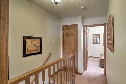 a hallway with a stairway with a wooden door at Red River Home with 2 Balconies - 1 Block to Main St in Red River