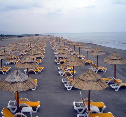 a row of chairs and umbrellas on a beach at Villa Elkom, App.11 in Donji Štoj