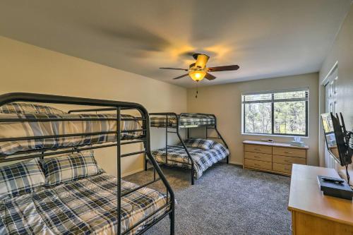 een slaapkamer met 2 stapelbedden en een plafondventilator bij Spacious Pinetop-Lakeside Home with Hot Tub on 1 Acre in Pinetop-Lakeside
