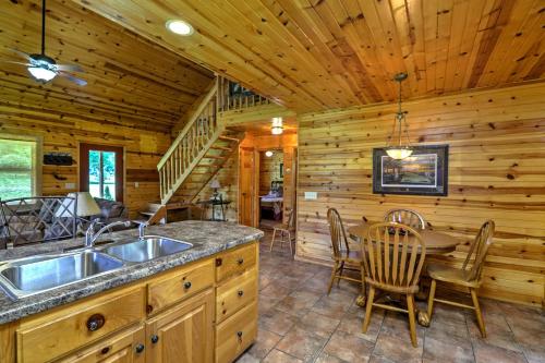 a kitchen and dining room in a log cabin at Dream Valley Mountain View Cabin with Covered Porch! in Mountain View