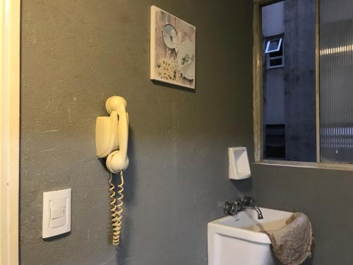 Una pared con un teléfono al lado de un urinario en French en Buenos Aires