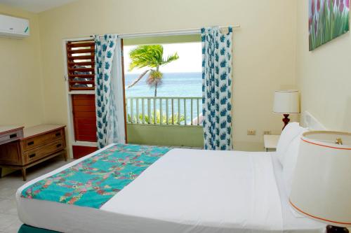 a bedroom with a bed and a view of the ocean at Ocean Palms in Ocho Rios
