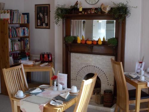 a dining room with a table and a fireplace at Swiss Court Guest House in Keswick