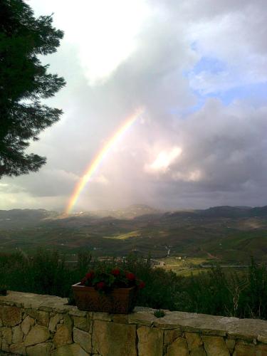 a rainbow in the sky with a pot of flowers at Turismo Rurale Baglio Fastuchera in Alcamo