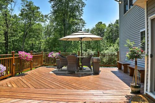 a wooden deck with a table and an umbrella at Colonial-Style Warwick Retreat - 1 Hour to NYC! in Warwick