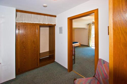 a room with a hallway with a door and a chair at Ferienwohnungen Appartements Patscheider in Finkenberg