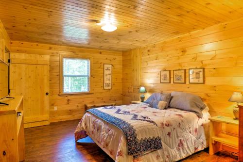 ein Schlafzimmer mit einem Bett in einer Holzhütte in der Unterkunft Peaceful Cabin Near Little River Canyon! in Fort Payne