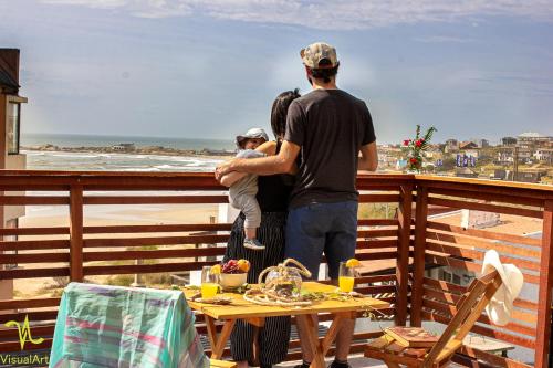 a group of people standing on a balcony looking at the beach at Lobos de Mar in Punta Del Diablo