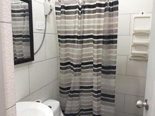 a bathroom with a shower curtain and a toilet at DEPARTAMENTO SAN BARTOLO-2dormitorios in Lima