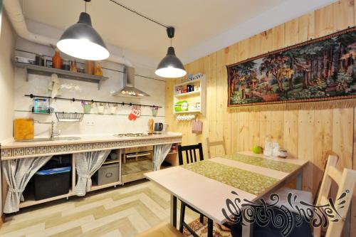 cocina con paredes de madera, mesa y fregadero en Scotch Hostel, en Volgograd