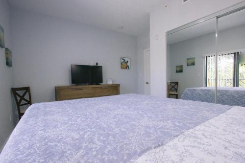 a bedroom with a bed and a flat screen tv at Vistalmar Beach Resort in Deerfield Beach