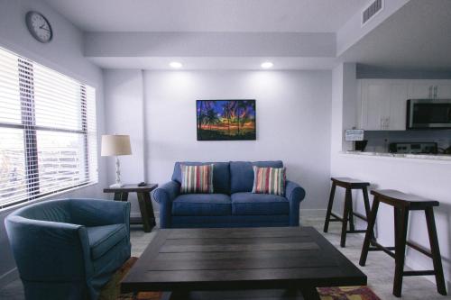 a living room with a blue couch and a table at Vistalmar Beach Resort in Deerfield Beach
