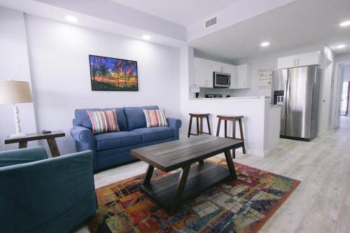a living room with a blue couch and a table at Vistalmar Beach Resort in Deerfield Beach