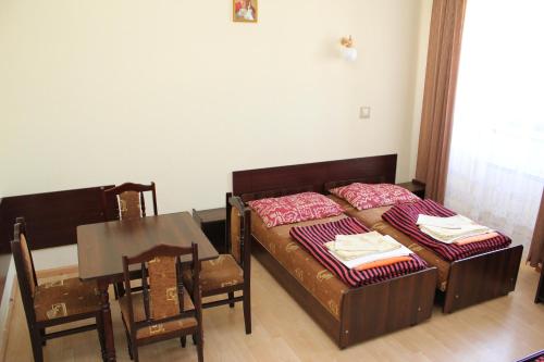 a bedroom with a bed and a table and chairs at Dom Pielgrzyma in Kalwaria Zebrzydowska