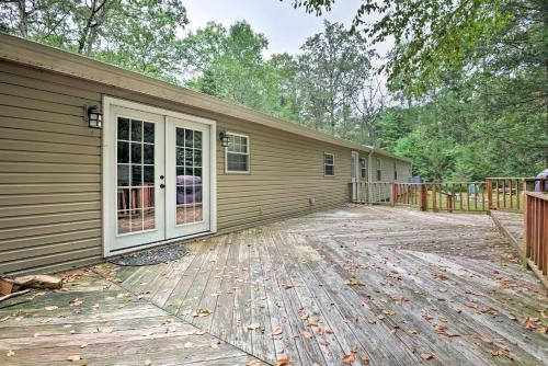 a house with a wooden deck next to a building at Spacious Kunkletown Home with Full Game Room and Deck! in Kunkletown