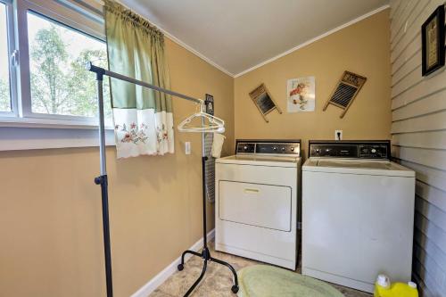 a laundry room with two washing machines and a window at Grandmas Farm House on 125 Acres with Fire Pit! in Beattyville