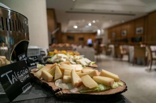 a plate of cheese and sandwiches on a table at Hotel Cappello D'Oro, BW Signature Collection in Bergamo