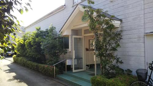a house with a front door and a porch at ペンション ラリー in Kawazu