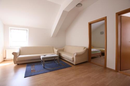a living room with two couches and a mirror at Motel Maks in Kiseljak