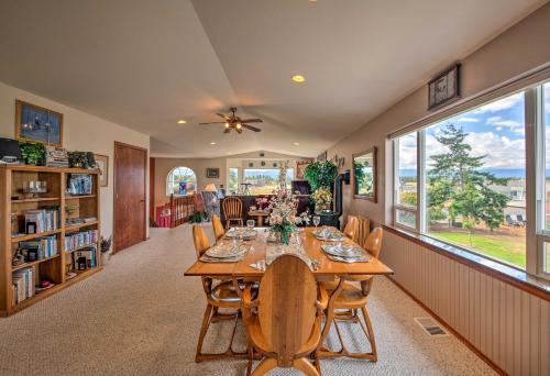 a dining room with a table and chairs and windows at Charming Sequim House with Olympic Peninsula Views! in Sequim