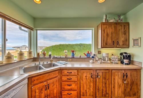 a kitchen with a sink and a large window at Charming Sequim House with Olympic Peninsula Views! in Sequim