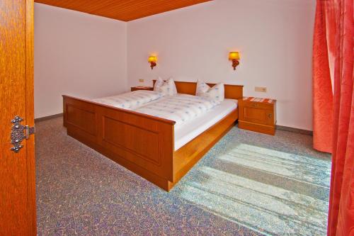 a bedroom with a large bed with white sheets at Ferienwohnungen Appartements Patscheider in Finkenberg