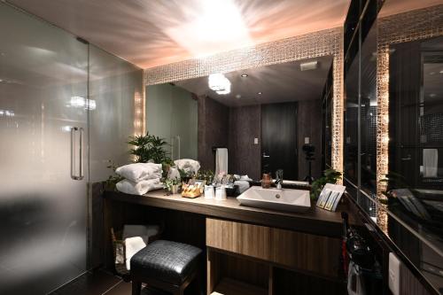 uma casa de banho com um lavatório e um espelho em HOTEL The Scene em Yokohama