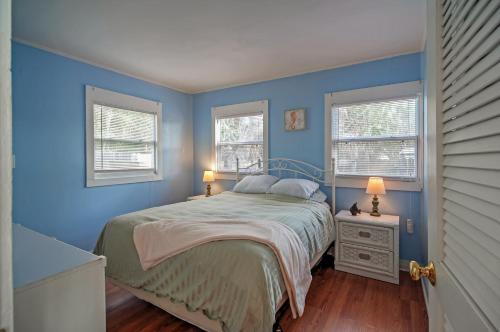 1 dormitorio azul con 1 cama y 2 ventanas en Quiet Cottage Less Than half Mi to Gulf Coast and Boardwalk!, en St Pete Beach