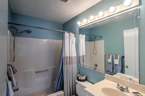 La salle de bains est pourvue d'un lavabo, d'une douche et d'un miroir. dans l'établissement Chic St Simons Townhome with Patio and Pool Access!, à Island Retreat
