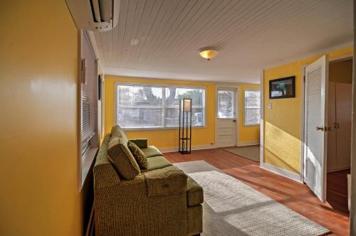 uma sala de estar com um sofá e paredes amarelas em Treasure Island Cottage, Near Boardwalk and Beach! em St. Pete Beach