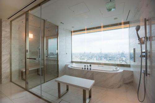a bath room with a tub and a mirror at The Prince Gallery Tokyo Kioicho, a Luxury Collection Hotel in Tokyo